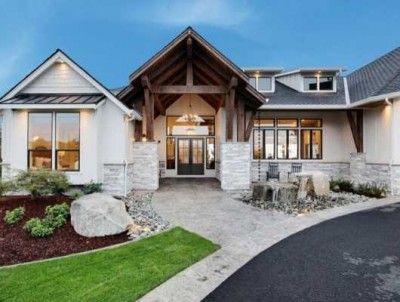 a large house with two car garages and lots of windows on the front of it