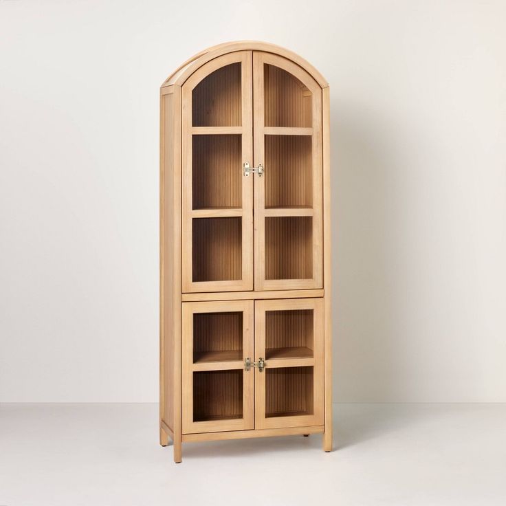 a wooden bookcase with glass doors on the front and bottom shelves, against a white background