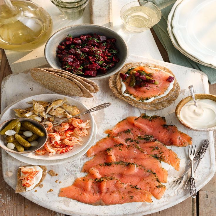 an assortment of food on a platter with bread, pickles and sauces