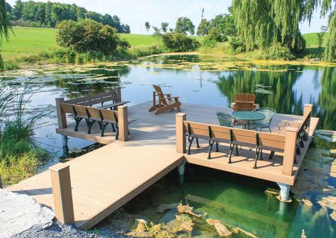 a wooden dock sitting next to a lake filled with green plants and water lilies