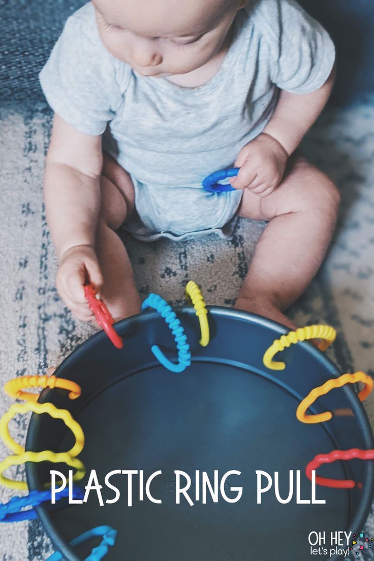 a baby sitting on the floor playing with plastic rings