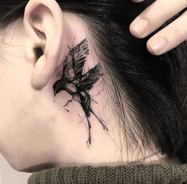 a woman with a black bird tattoo on her neck