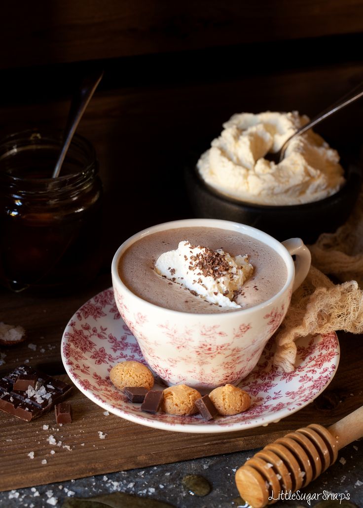 a cup of hot chocolate with marshmallows and graham crackers on the side