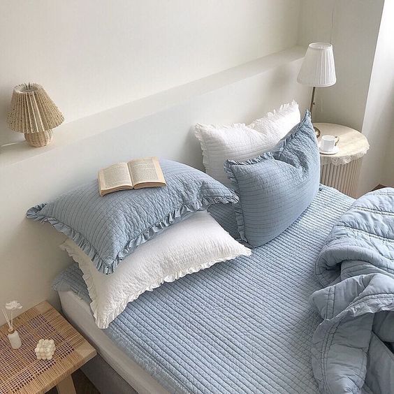 a bed that has some pillows on it and a book sitting on top of it