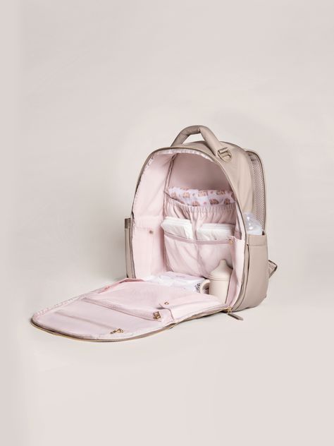 an open pink backpack with its contents in the back and side zippers down, on a white background