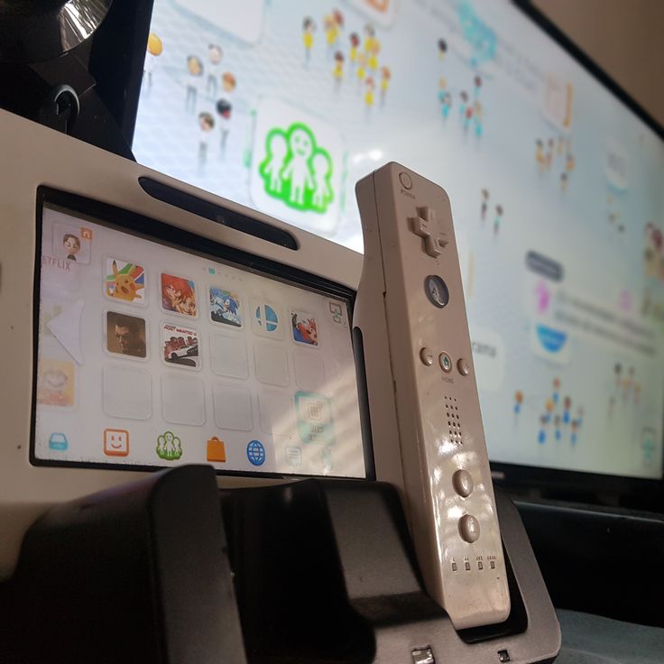 two nintendo wii remotes sitting next to each other in front of a flat screen tv