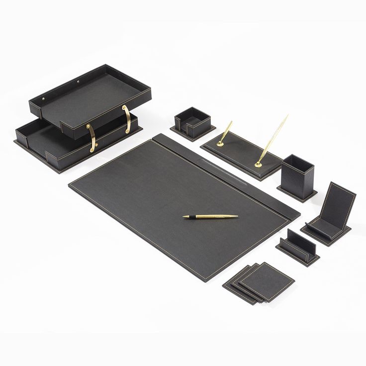 a set of black desk accessories including pen, paper holder and tray with gold handles