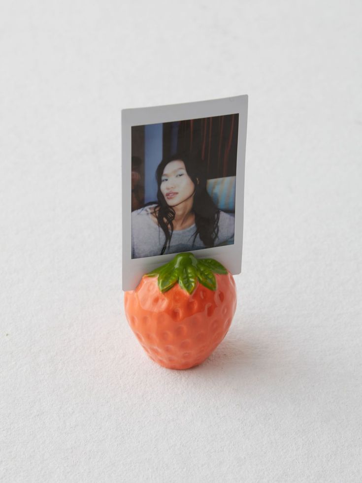 an orange toy with a photo attached to it's side on a white surface