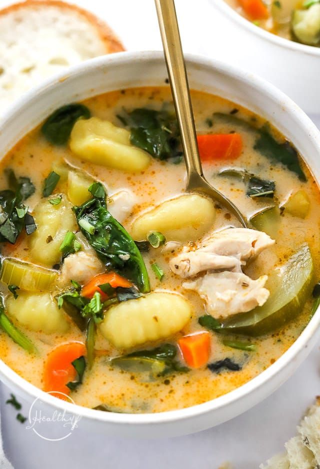 two white bowls filled with chicken and vegetable soup