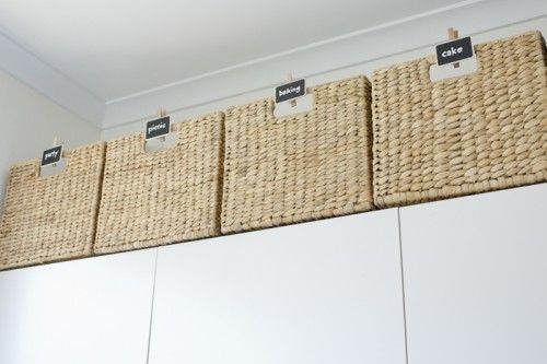 three baskets are hanging on the wall above some cupboards with labels that read'sale '