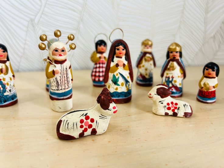 a group of small figurines sitting on top of a wooden table next to each other