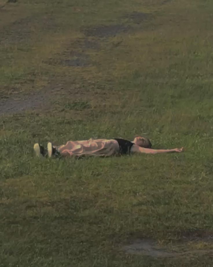 a man laying on the ground in a field