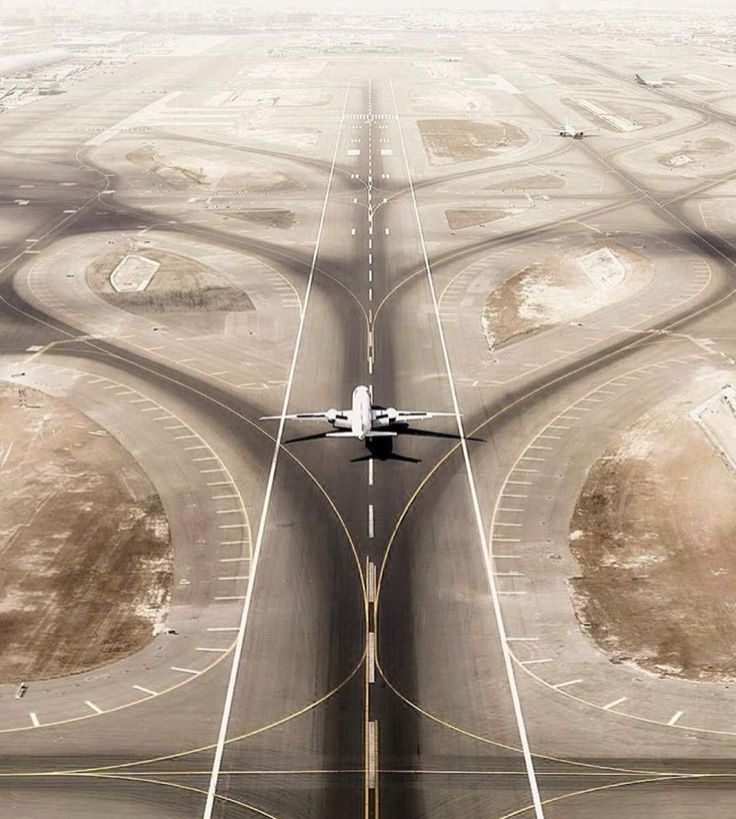 an airplane is flying over the airport runway