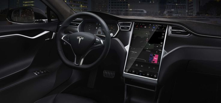 the interior of a tesla model s car at night with city lights in the background