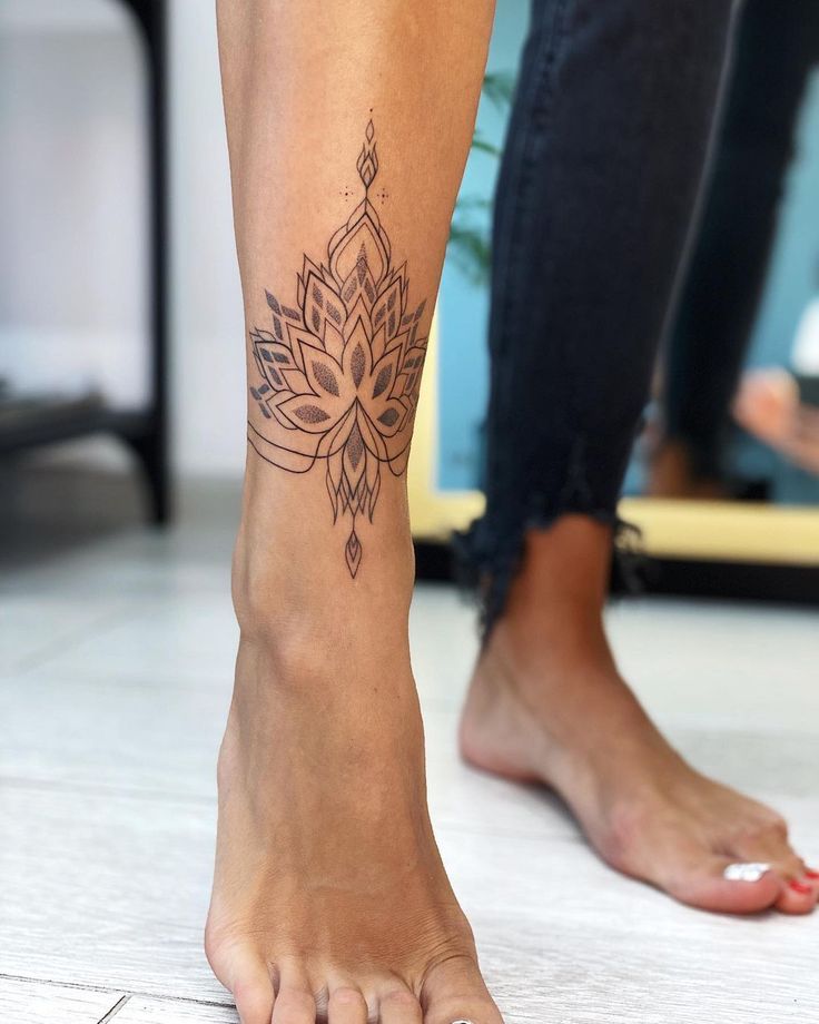 a woman's foot with a tattoo design on the lower part of her leg