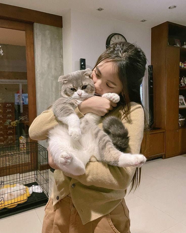 a woman holding a cat in her arms