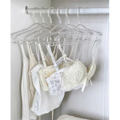 several bras hanging on a rack in a closet