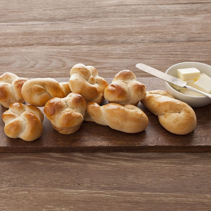 bread rolls and butter on a wooden cutting board