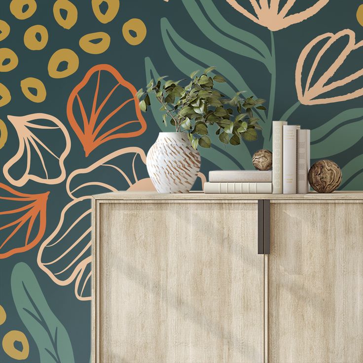 a vase with flowers and books on top of a dresser next to a wallpaper