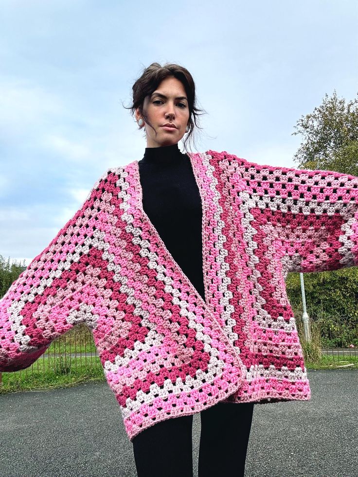 a woman wearing a pink and white crocheted sweater