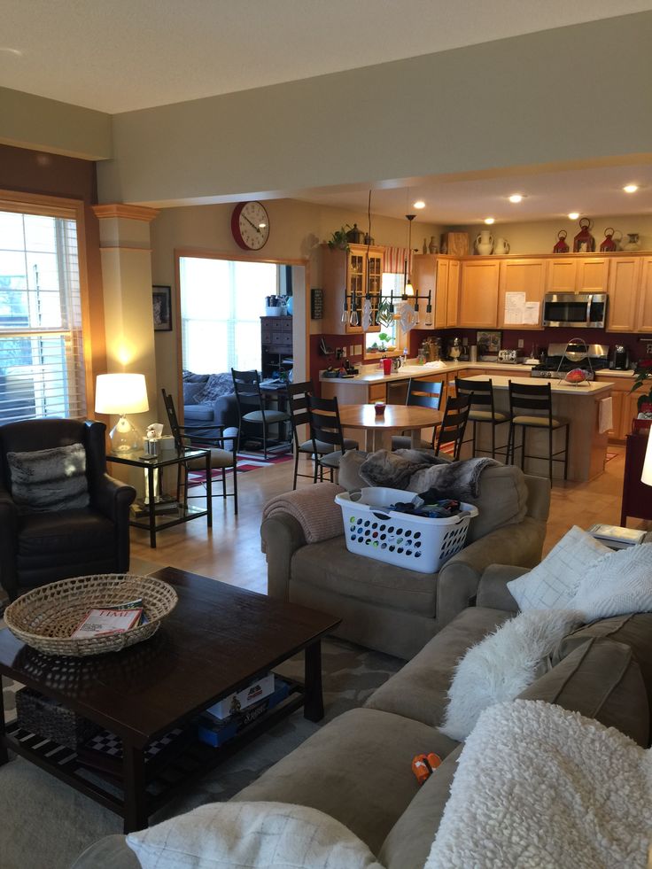 a living room filled with furniture next to a kitchen