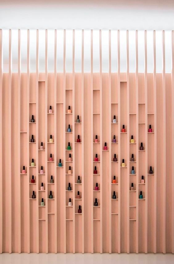 the wall is lined with shelving and shelves filled with different colored bottles on each shelf