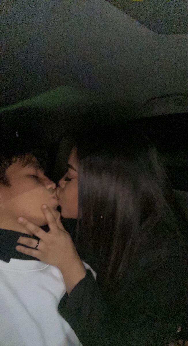 two people kissing each other in the back of a car