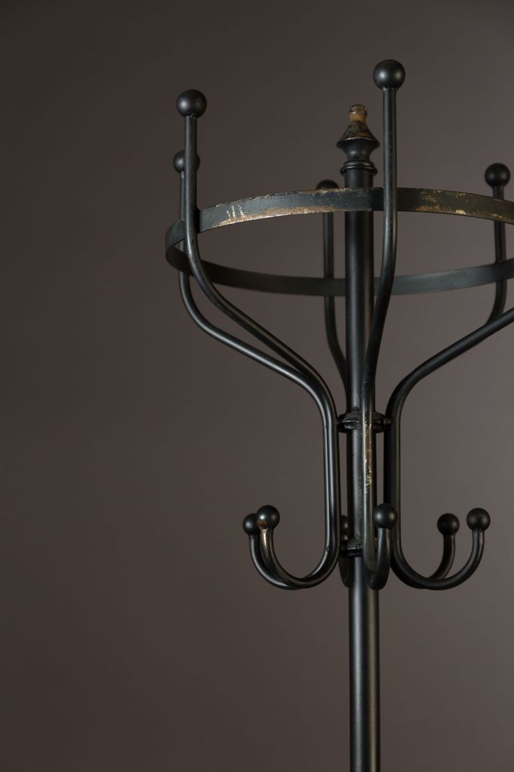 an iron candelabra with three candles on it's sides and one candle holder in the middle