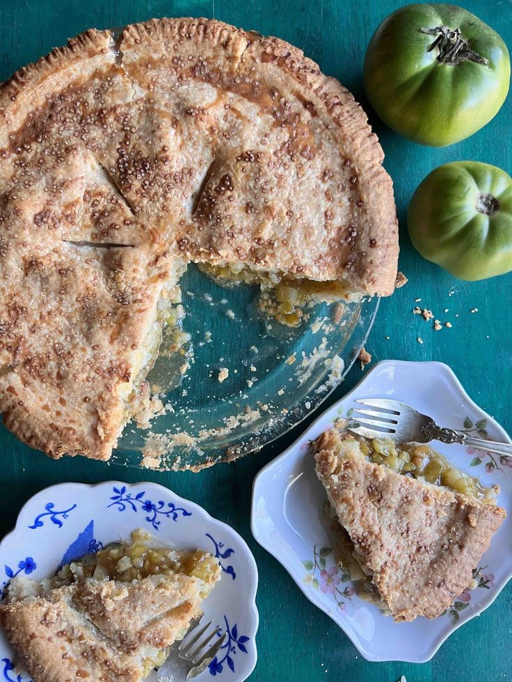 there is a pie on the table and two plates with one slice missing from it