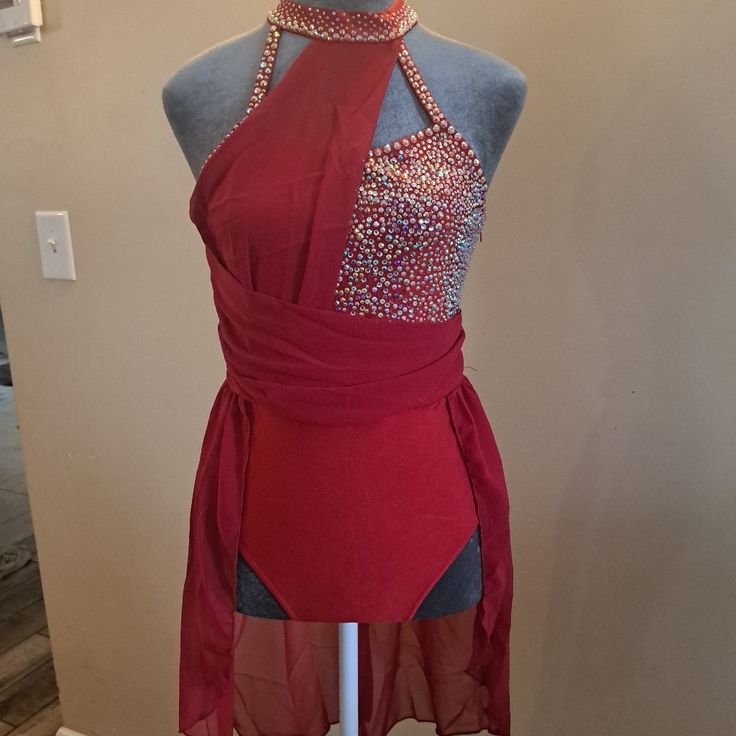 a mannequin wearing a red dress with silver beading on the neckline