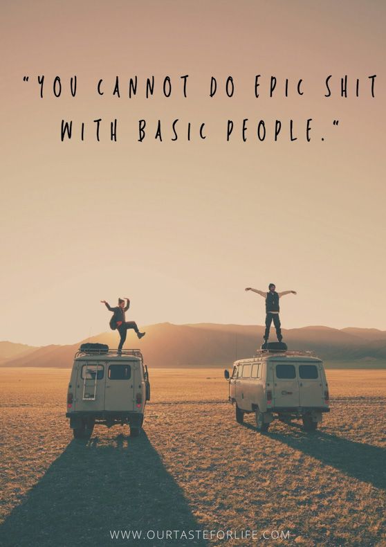 two people standing on top of a van in the desert