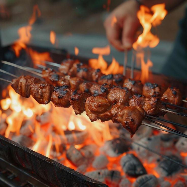 someone is cooking meat on a grill with flames