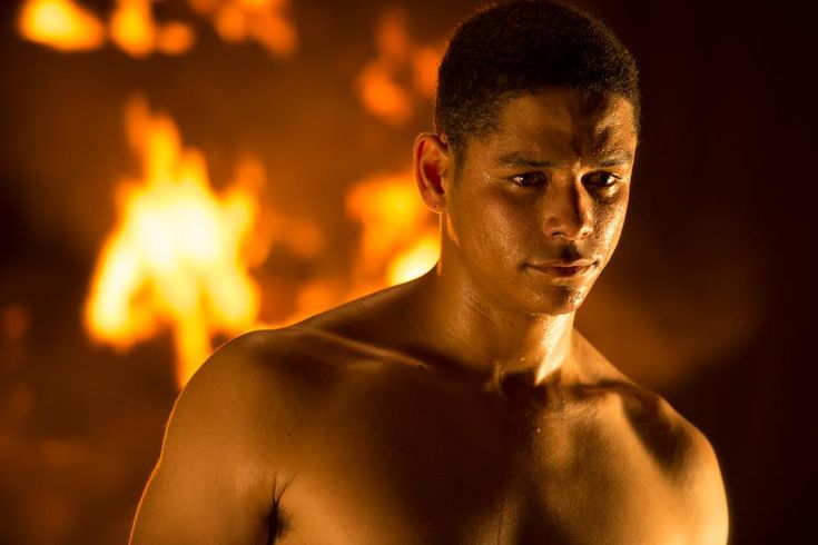 a shirtless man standing in front of a fire with the chicago fire logo on it