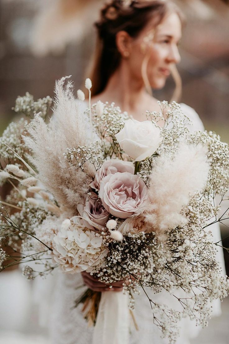 a woman holding a bouquet of flowers and feathers