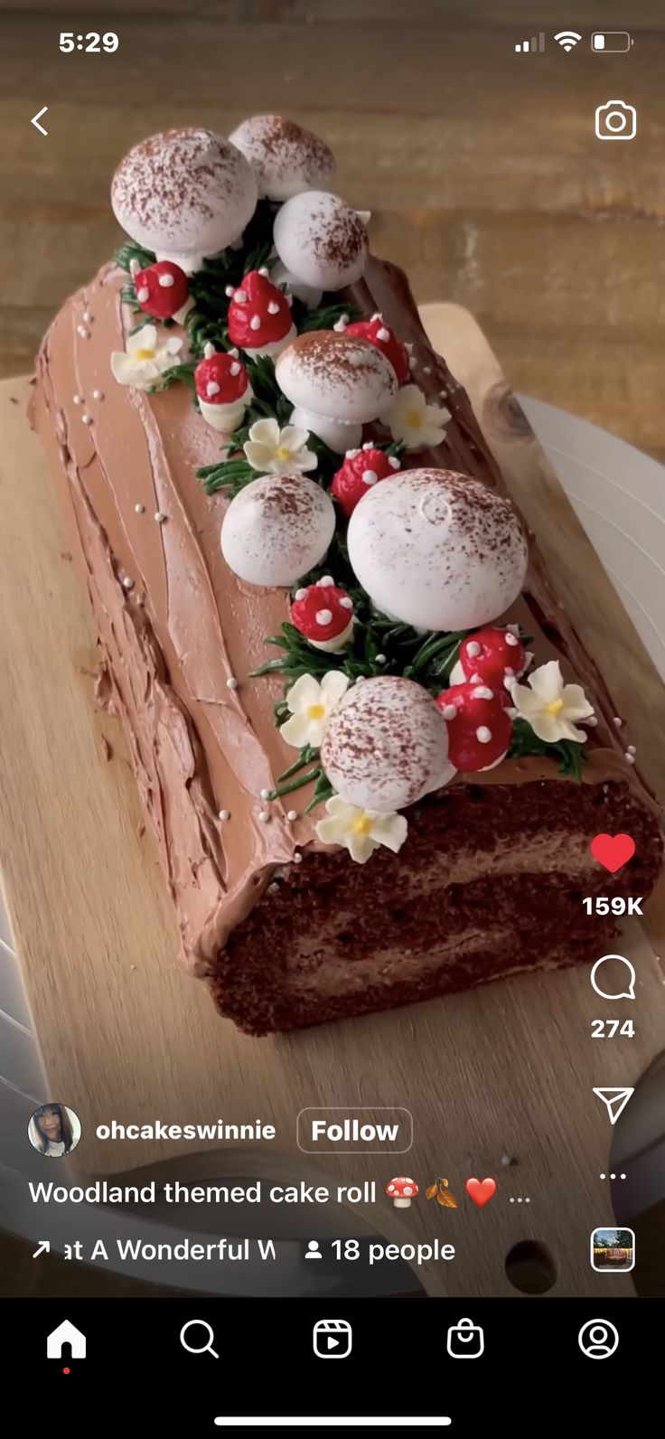 a piece of chocolate cake with frosting and berries on top sitting on a wooden cutting board