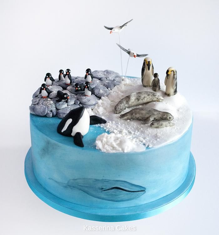 there is a cake with penguins and birds on it