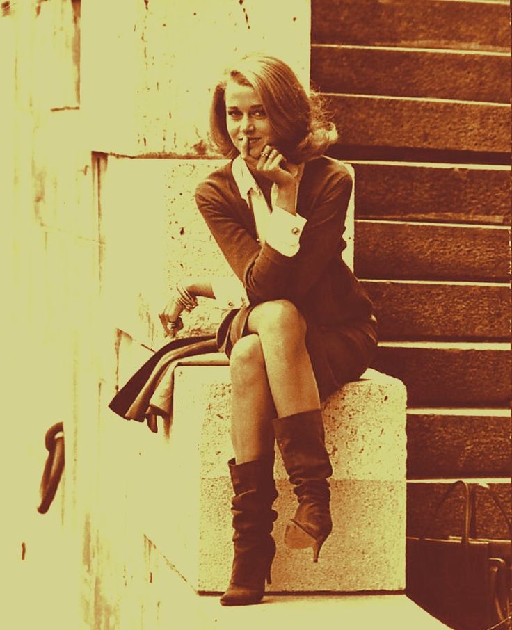 black and white photograph of a woman sitting on steps talking on her cell phone while looking off to the side