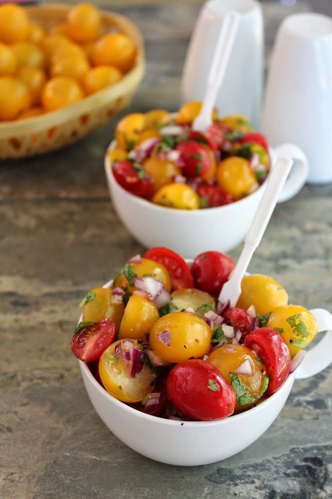 two bowls filled with different types of food on top of a marble counter next to white dishes