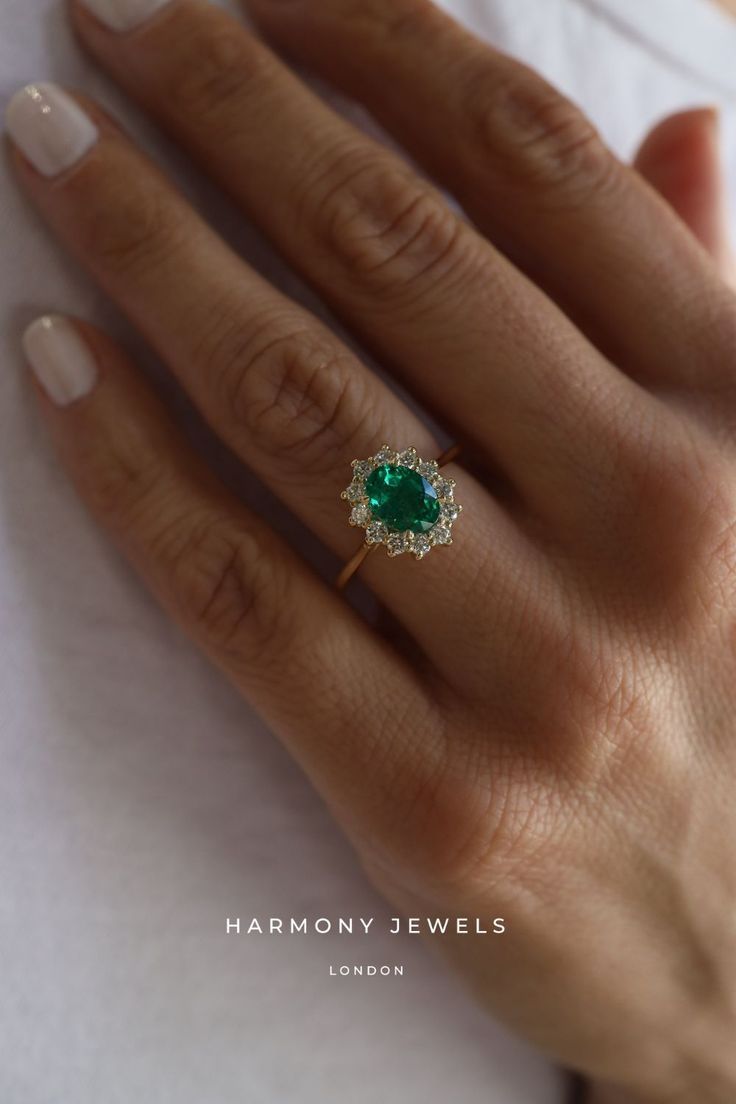 a woman's hand with a green ring on it