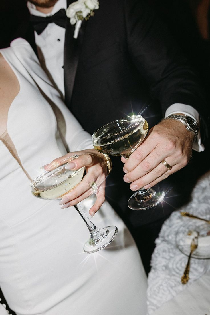 a man and woman holding wine glasses in their hands