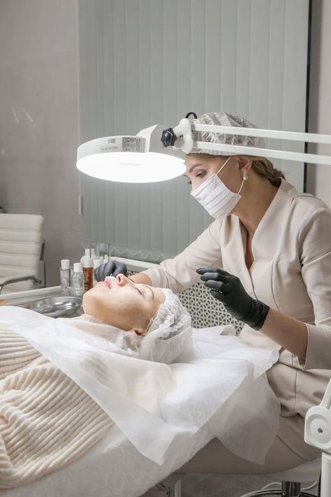 a woman is getting her hair cut by a doctor in a room with white walls