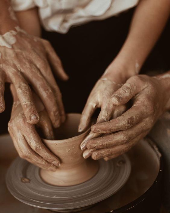 two hands that are on a potter's wheel