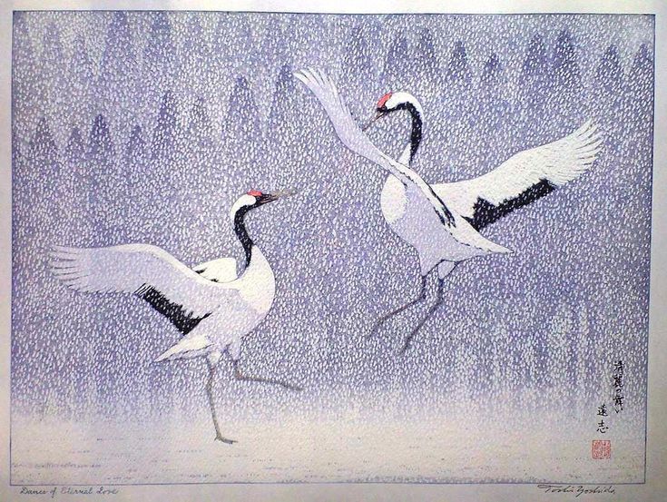 two birds are flying in the air near trees and snowflakes on a snowy day