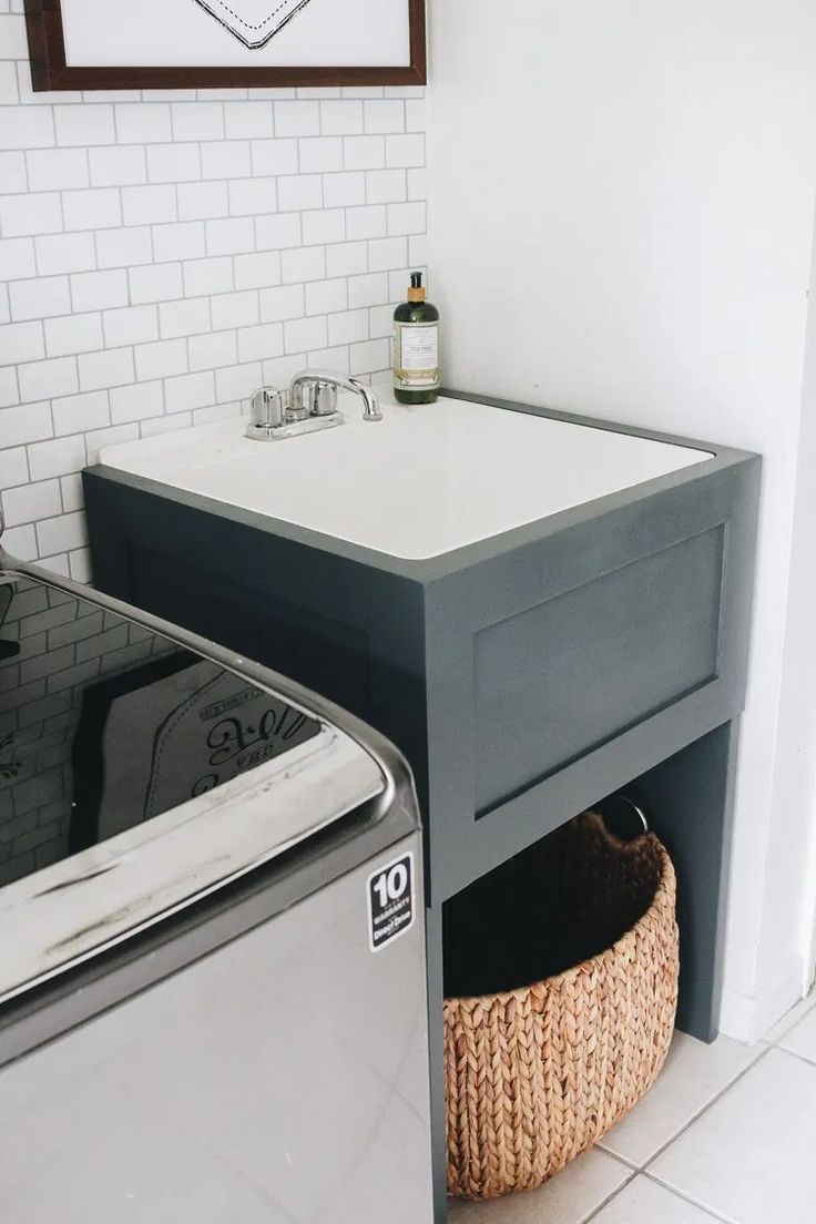 a washer and dryer sitting next to each other in a room with white tiles on the walls