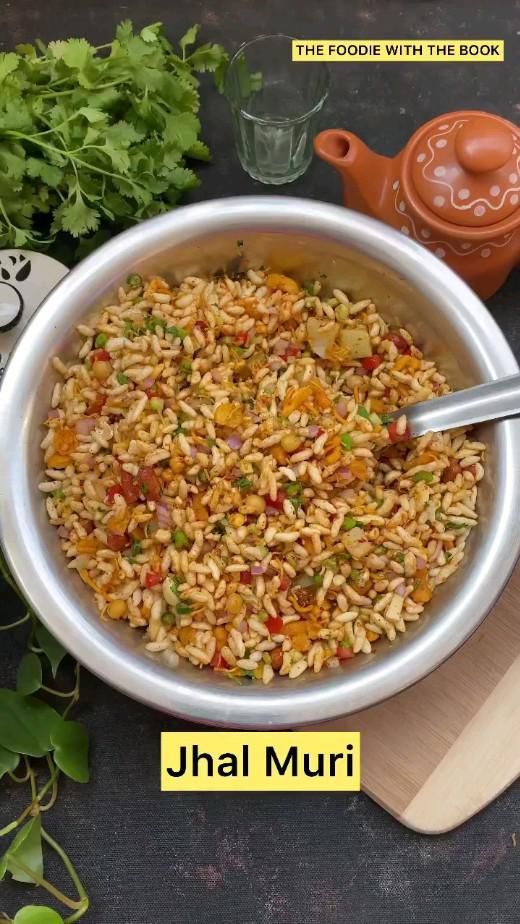 a bowl filled with rice and vegetables on top of a wooden cutting board next to a teapot