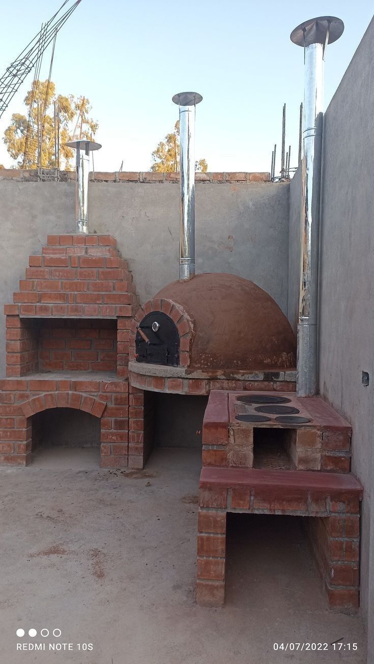 an outdoor pizza oven in the middle of a building