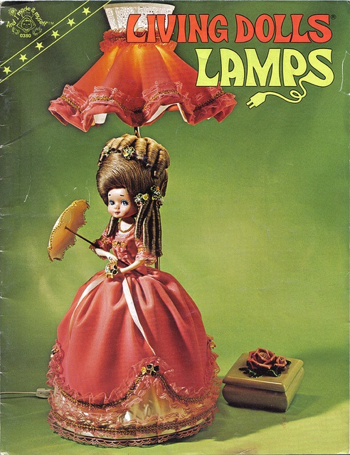 the doll is wearing a red dress and holding an umbrella with her hair in braids