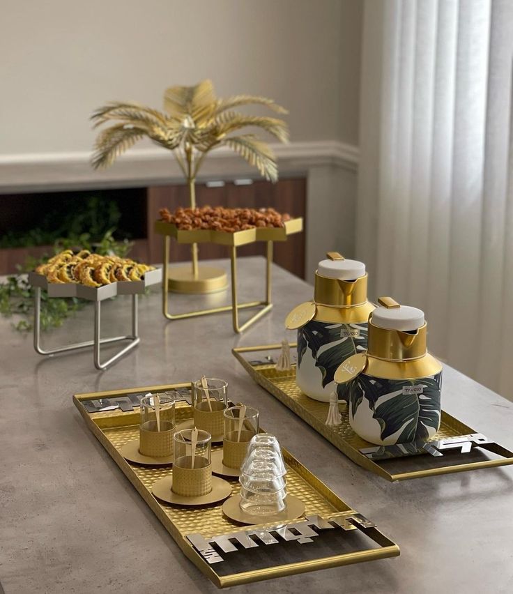 a table topped with plates and trays filled with desserts on top of it