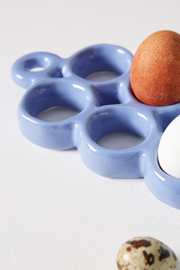 an egg is sitting in the middle of some blue rings and eggs are on the ground