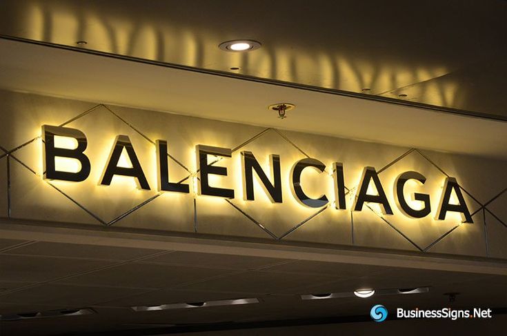 a sign that reads balenicaga above the entrance to a building at night